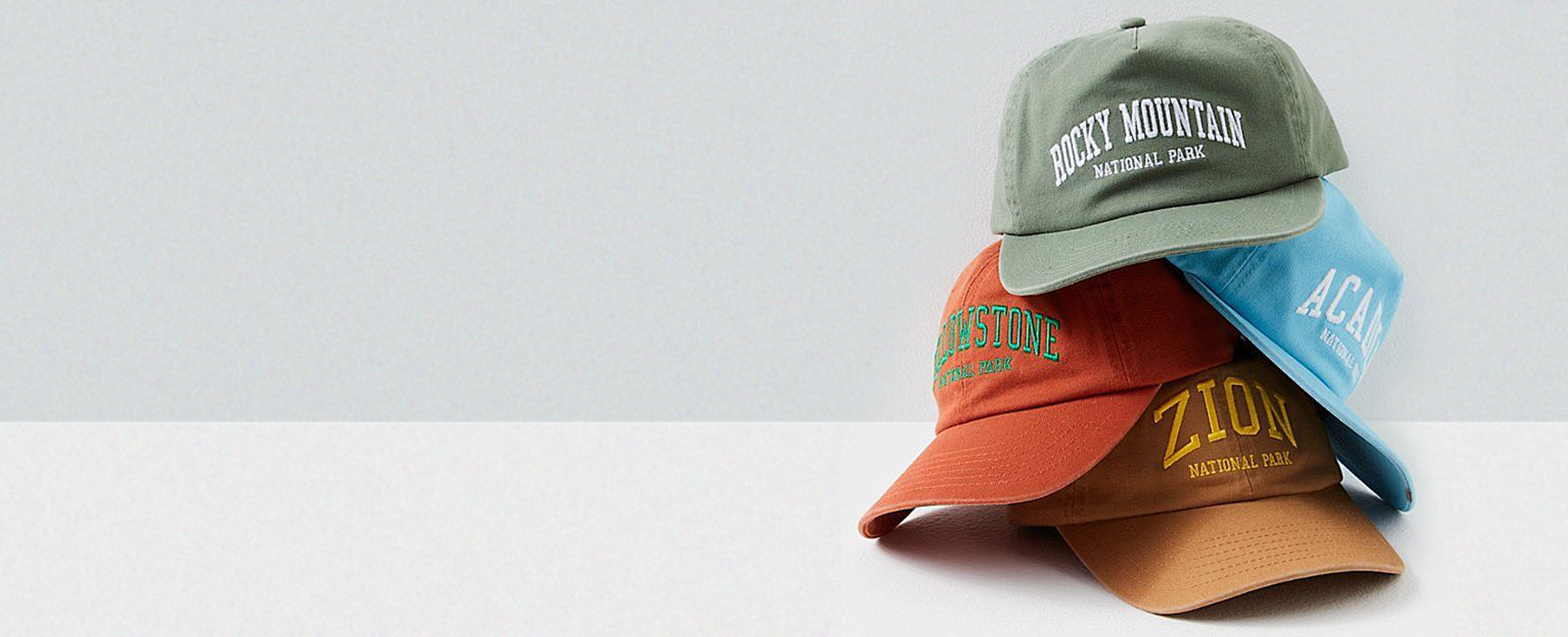 Four baseball caps with different text designs on a light gray background - athleticedgefashion